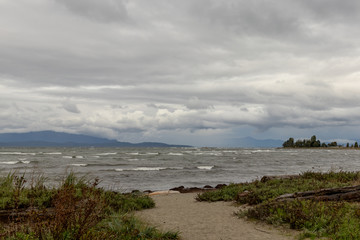 Fototapeta na wymiar storm clouds over the sea, wave beach and mountain