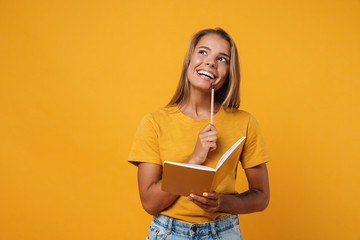 Image of young happy woman thinking and holding exercise book