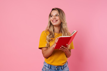 Happy woman writing notes in notebook