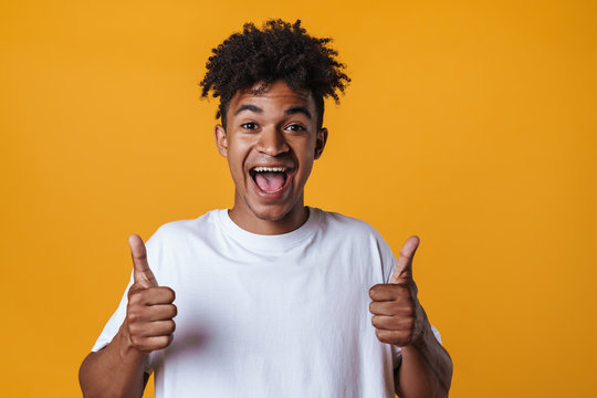 Image of excited african american guy showing thumb up at camera