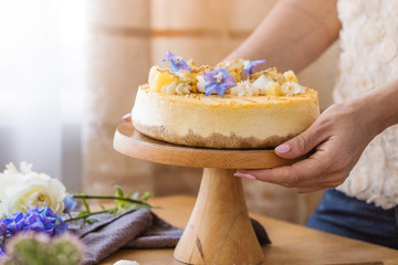 Caramel apple pear cheesecake. Close up side view stone kitchen table, side view. Autumn dessert. Woman decorated apple cake