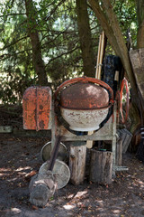 an old concrete mixer standing in the corner of a country backyard