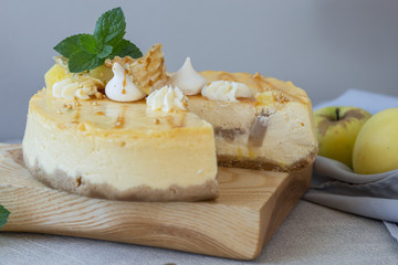 Caramel apple pear cheesecake. Close up side view stone kitchen table, side view. Autumn dessert. Woman decorated apple cake