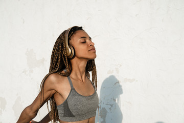 Fototapeta premium Image of african american girl using headphones while working out