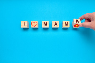 Person placing wooden cubes with a heart and the words I and MAMA