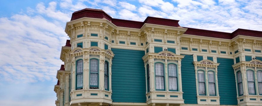 Closeup of traditional house in the city of Ferndale in Humboldt County, California, USA, famous for its Victorian architecture, a sunny day with blue sky and clouds in summer, space for text