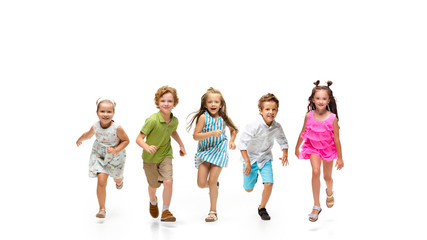 Happy children, little and emotional caucasian kids jumping and running isolated on white background. Looks happy, cheerful, sincere. Copyspace for ad. Childhood, education, happiness concept.