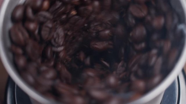 Fine coffee beans grinding. Close up on coffee grinding chamber.