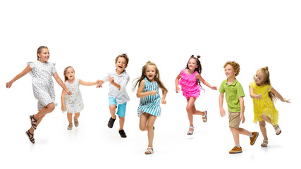 Happy children, little and emotional caucasian kids jumping and running isolated on white background. Looks happy, cheerful, sincere. Copyspace for ad. Childhood, education, happiness concept.