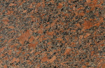The texture of the rock granite in red and black tones.