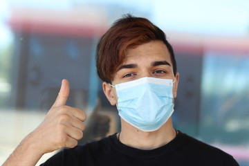 The guy in the medical mask shows a thumbs up.