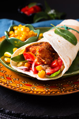 Home cooking concept Organic Homemade Fried chicken burrito tortilla sandwich on color plate and black copy space.