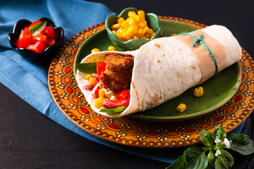 Home cooking concept Organic Homemade Fried chicken burrito tortilla sandwich on color plate and black copy space.