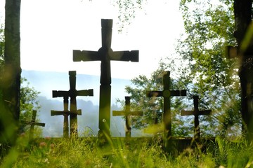 First World War cemetery with wooden crosses and brick monument in the village of Krempna in morning light. Low Beskids Mountains, Poland