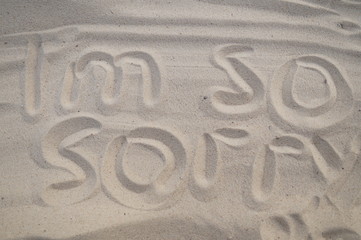 The inscription on the white sand "I'm so sorry"