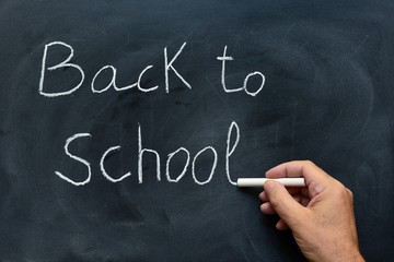 Vuelta al colegio escrito a mano con tiza en la pizarra