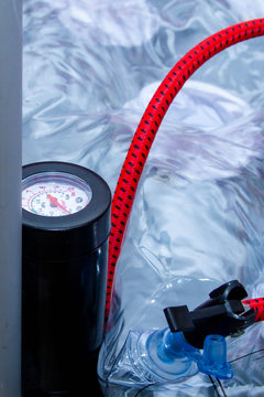 Pump with red hose and barometer, air pressure sensor for inflating rubber products.