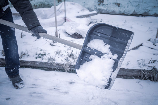 Clean Snow In Winter With A Shovel. A Man Shovels Snow From The Path In The Garden. Working In A Private Home After A Snowfall.