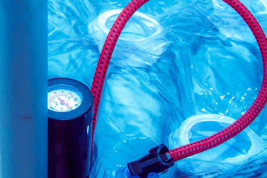 Pump with red hose for inflating the rubber circle for swimming.