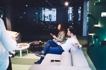 Cheerful colleagues listening to manager in workplace