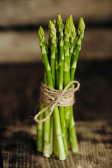 Bunch of fresh green asparagus on wood board. Close up