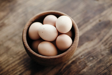 Organic eggs in wooden plate on wooden table.