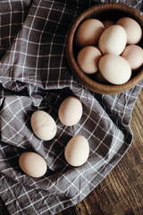 Organic eggs in wooden plate on wooden table.