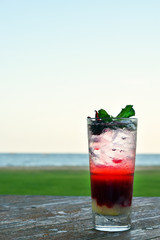Vertical photo, Strawberry Soda in a tall glass with blurred view background.