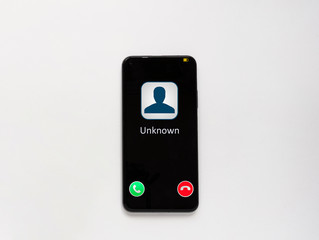 A phone call from an unknown number. Scam, scam or phishing with smartphone concept. An unknown number is ringing. Telephone on a white background.