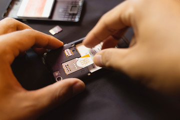 Employees are changing the phone SIM card, nano SIM card in the shop for customers to buy, Man's...