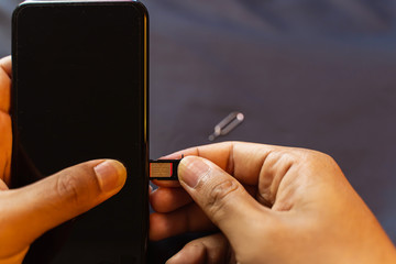 Employees are changing the phone SIM card, nano SIM card in the shop for customers to buy, Man's...