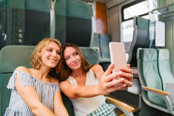 Young women taking pictures of themselves in train