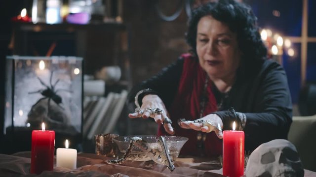 Witch performing ritual with two snakes and bowl of water