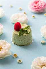 Fototapeta na wymiar Pistachio mousse cake, cheesecake with fresh raspberry on white plate with mint leaves