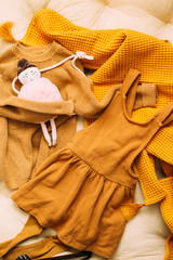 Baby autumn style clothes concept of child fashion. Flat lay children's clothing and accessories. Baby template background with copy space. Top view fashion trendy look of baby clothes and toy stuff.