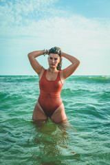 Beautiful young European woman with an orange swimsuit at the sea in Cádiz