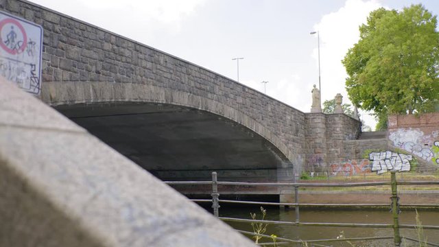 Small moat passing under a brick historical bridge, Pupenbruecke Luebeck 