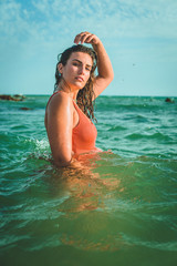 Beautiful young European woman with an orange swimsuit at the sea in Cádiz