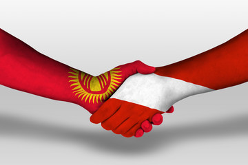 Handshake between austria and Kyrgyzstan flags painted on hands, illustration with clipping path.