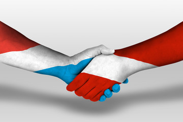 Handshake between austria and luxembourg flags painted on hands, illustration with clipping path.