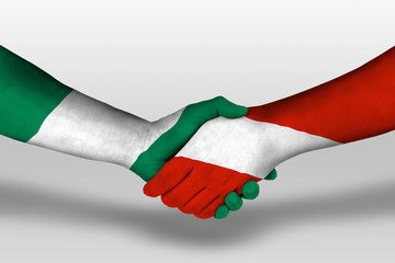 Handshake between austria and nigeria flags painted on hands, illustration with clipping path.
