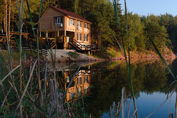 Obraz premium country house with reflection in the water in the warm light of the rising sun