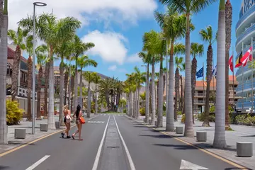 Foto auf Acrylglas Kanarische Inseln Two women crossing an empty road in a now deserted area, usually bustling with tourists enjoying the restaurants, venues and hotels around, Playa de Las Americas, Tenerife, Canary Islands, Spain