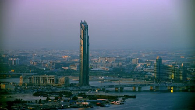 Aerial shot zooming in slow at the D1 Tower, Palazzo Versace and the Jaddaf Waterfront Marina which is near the Business Bay Crossing Bridge, 6-axis stabilized gimbal, Shotover F1, 8K, parallax.