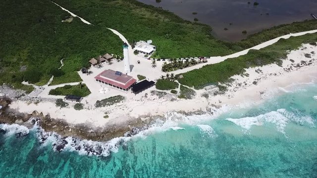 Drone footage of view on beautiful rocky beach and Lighthouse with crystal clear water splashing on shore line -Cozumel  Mexico
