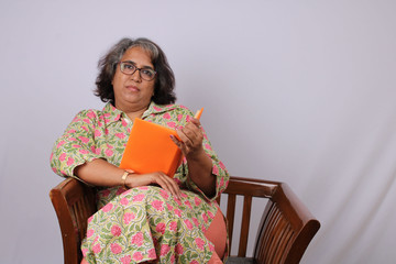 Mature Indian woman reading book