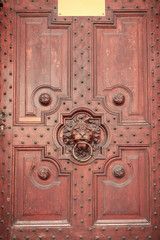 wooden carved door with a handle in the form of a lion s head
