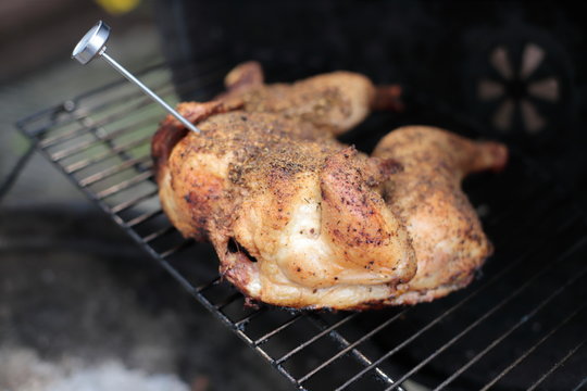 Meat Thermometer In A Chicken On The BBQ Grill.