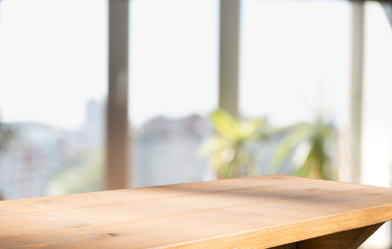 Wooden table on defocuced window with curtain background