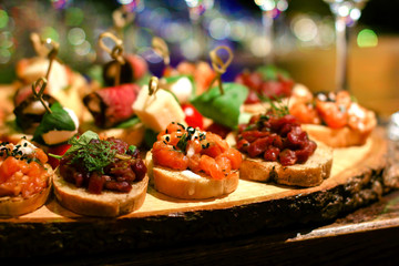 set of many different bruschettas at wooden table top. italian cuisine appetizer with tar tare